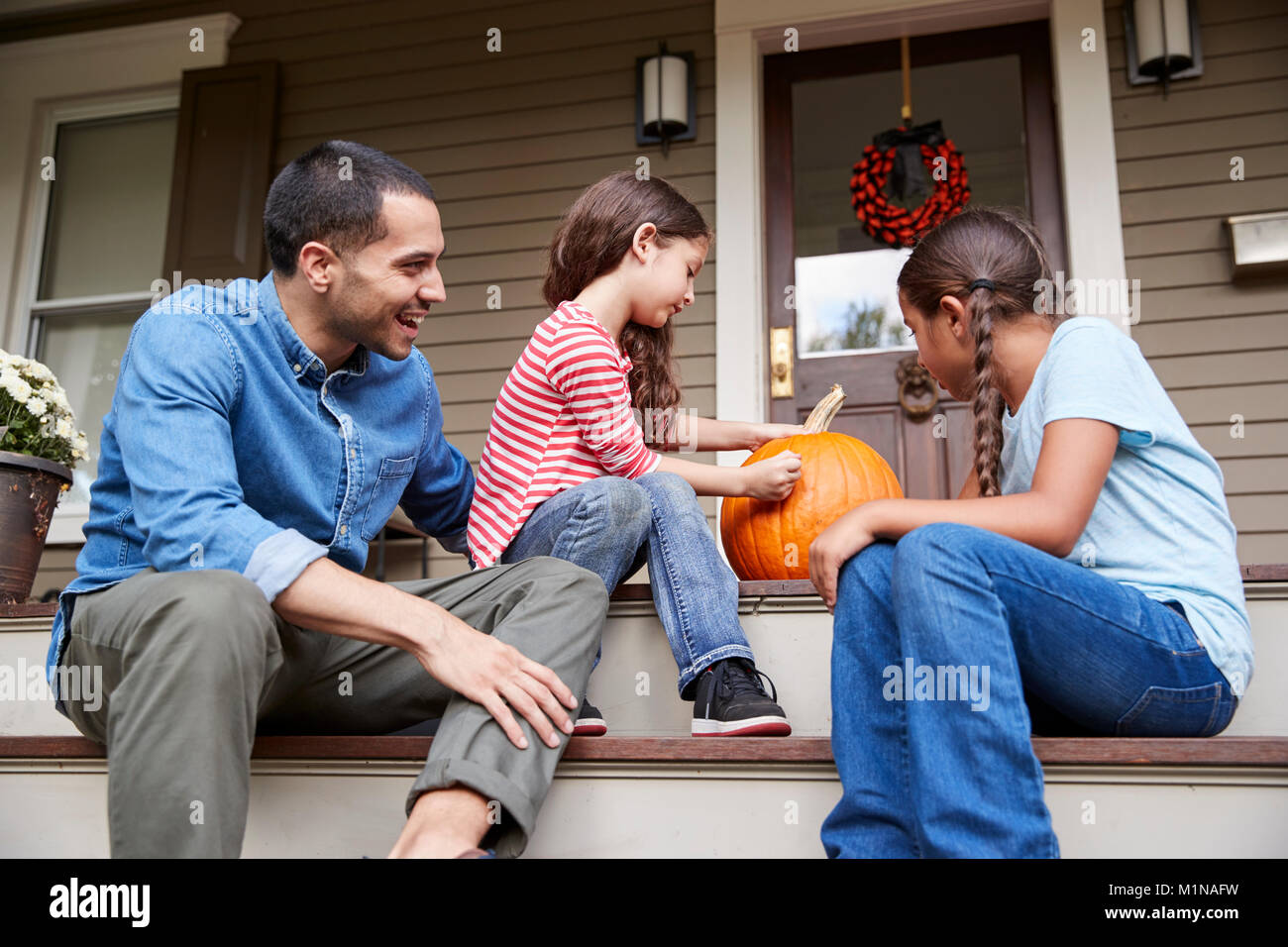 Padre e Figlie disegno volto sulla zucca di Halloween Foto Stock