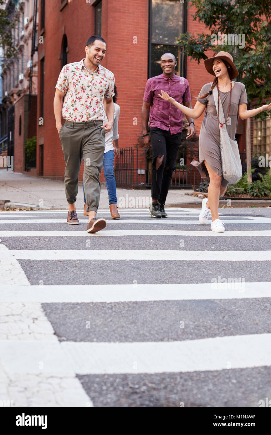 Gruppo di amici attraversamento strada urbana a New York City Foto Stock