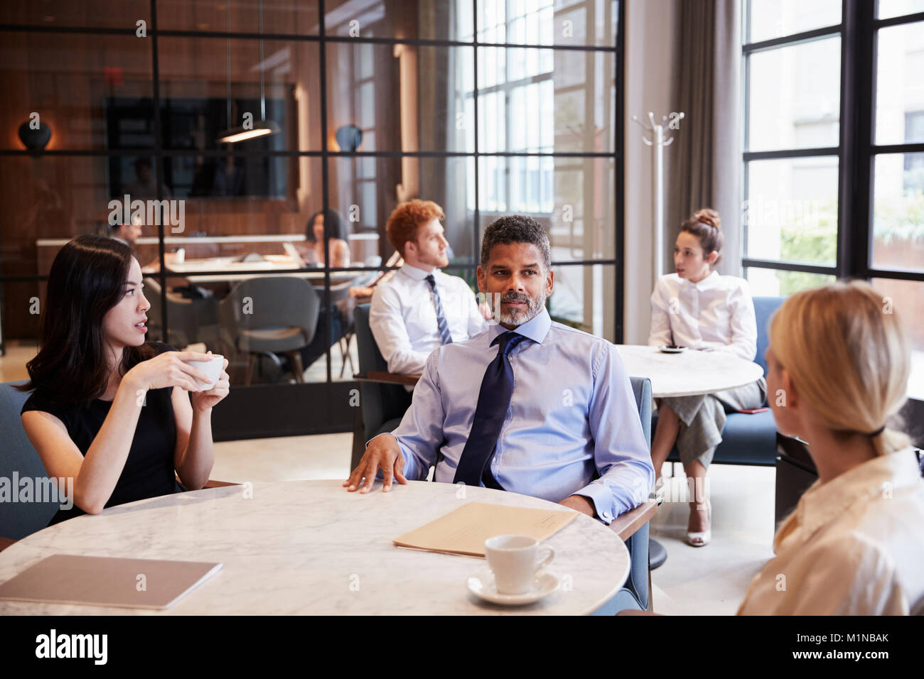 Colleghi di lavoro che parlano al loro ufficio cafe Foto Stock