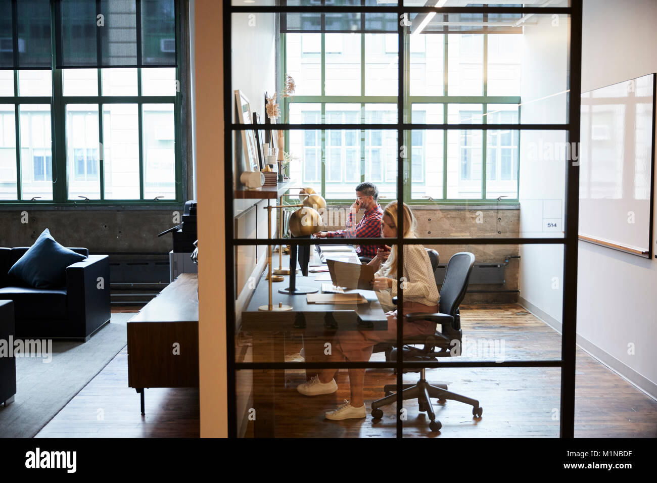 Il team Aziende che lavorano in un vetro a parete cabina di office Foto Stock