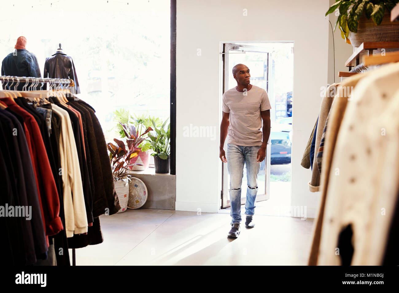 Giovane uomo nero a piedi in un negozio di abbigliamento Foto Stock