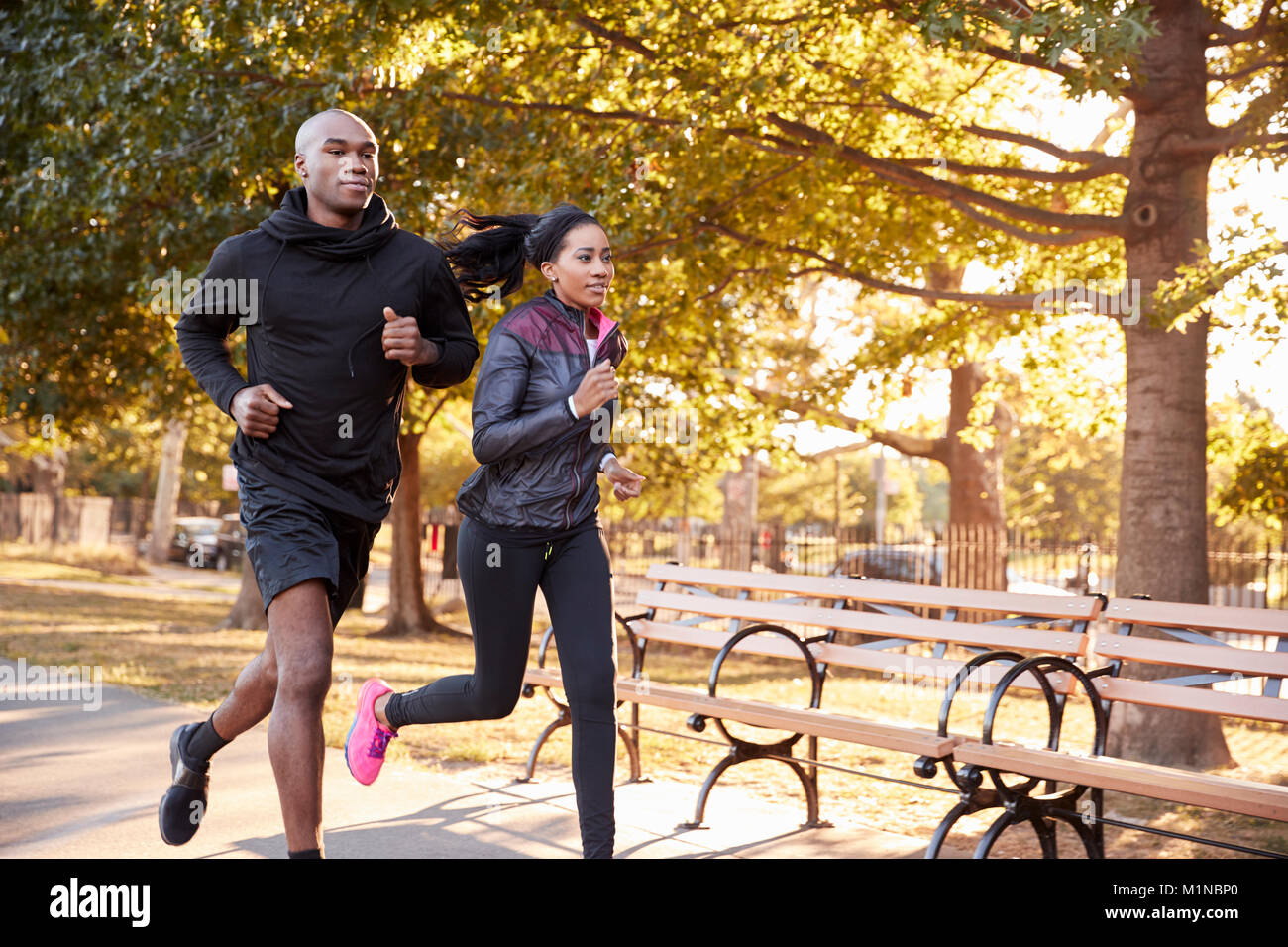 Giovane nero giovane jogging in un parco di Brooklyn, tre quarti di lunghezza Foto Stock
