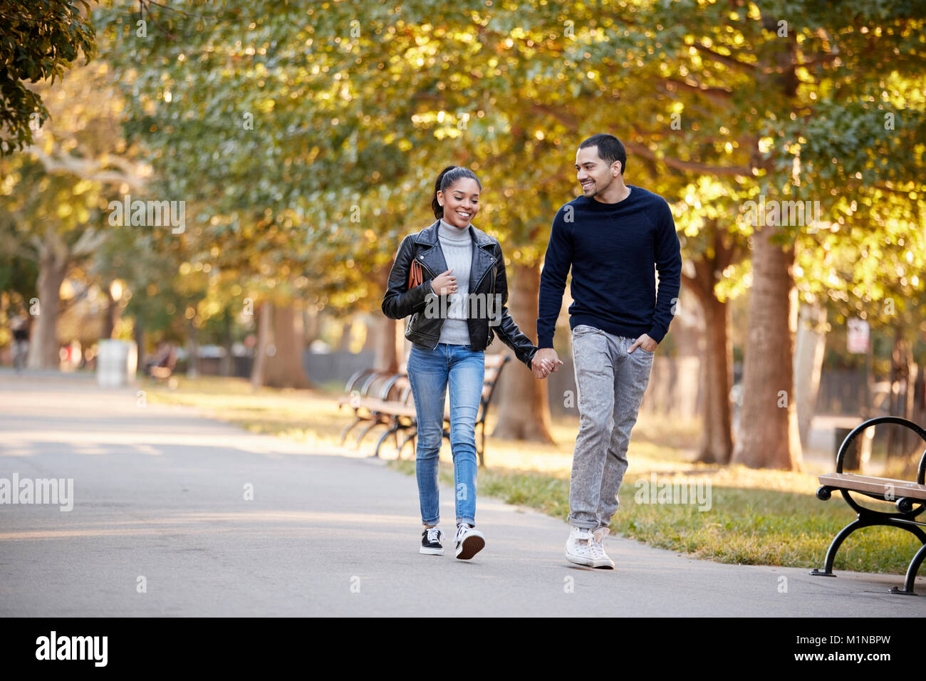I giovani ispanici giovane camminando mano nella mano in Brooklyn Park Foto Stock