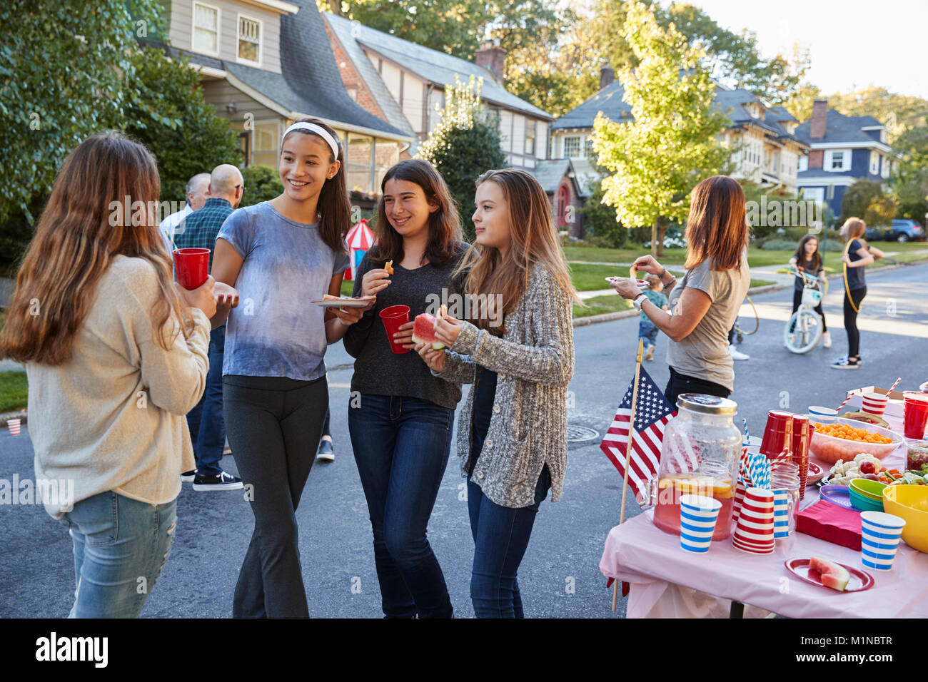 Gli adolescenti a parlare in strada in un block party Foto Stock