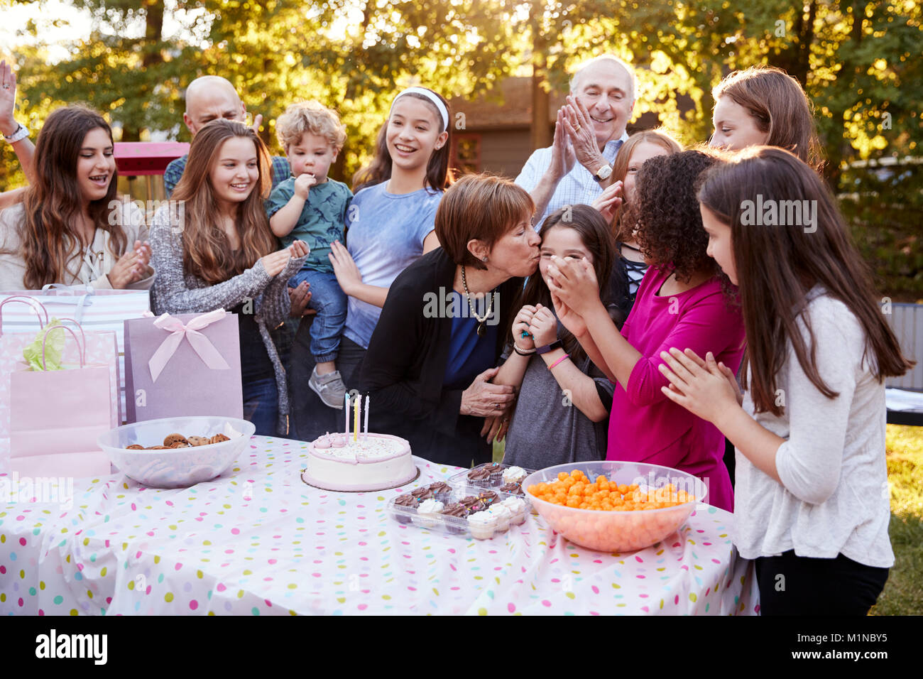 La famiglia e gli amici si sono riuniti presso un giardino festa di compleanno Foto Stock