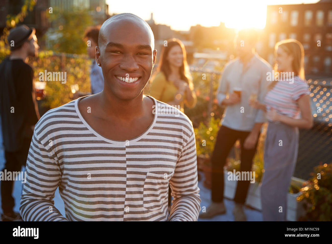 Giovane uomo nero a un tetto parte sorridente alla fotocamera Foto Stock