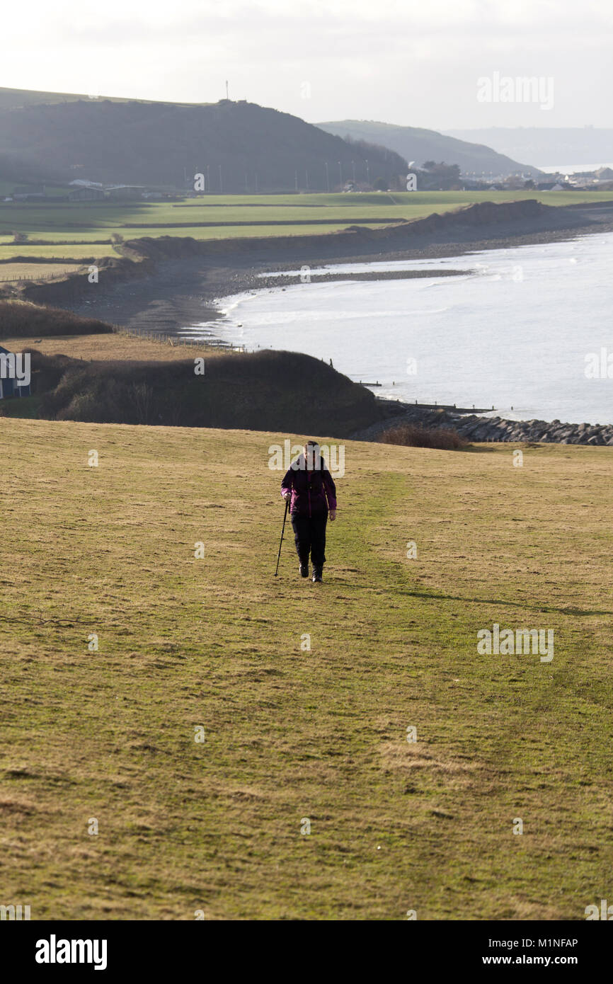 Il Galles e Ceredigion Coast Path. Vista pittoresca di un viandante sul sentiero costiero itinerario tra il villaggio di Llanon e la città di Aberaeron. Foto Stock