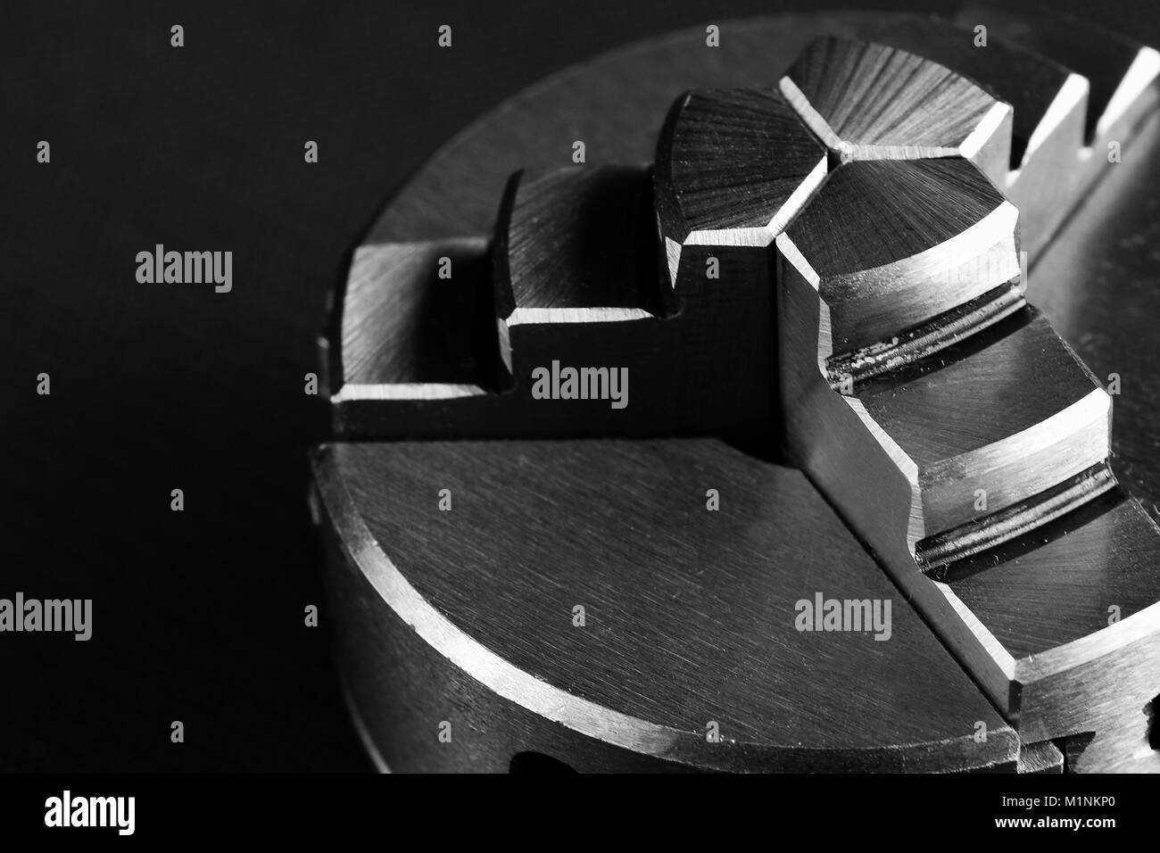 Immagine stilizzata di metallo tornio 3 morse su sfondo nero. Foto Stock