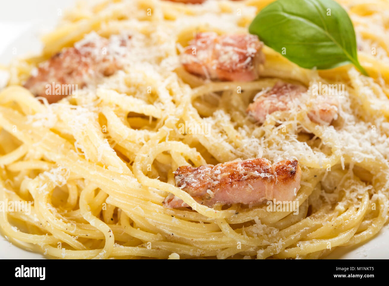 La piastra con i tradizionali piatti di pasta italiana Carbonara con parmigiano e basilico Foto Stock