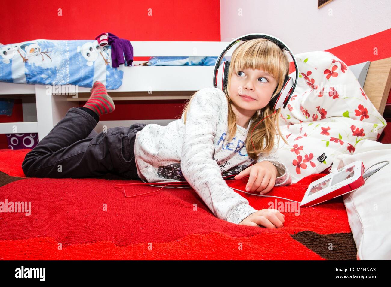 6 anno vecchia ragazza con le cuffie su gioca con un Nintendo DS su un letto, Kernen, Germania, nov. 5, 2017. | Utilizzo di tutto il mondo Foto Stock