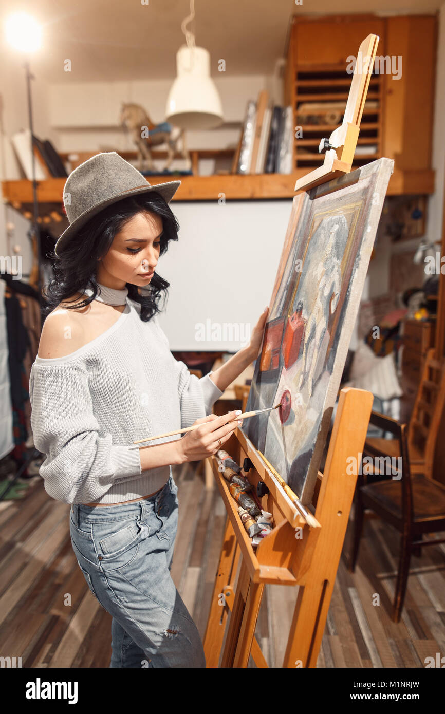 Ragazza sorridente pitture su tela con colori ad olio in laboratorio Foto Stock