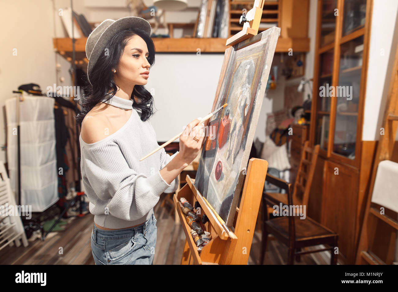 Ragazza sorridente pitture su tela con colori ad olio in laboratorio Foto Stock