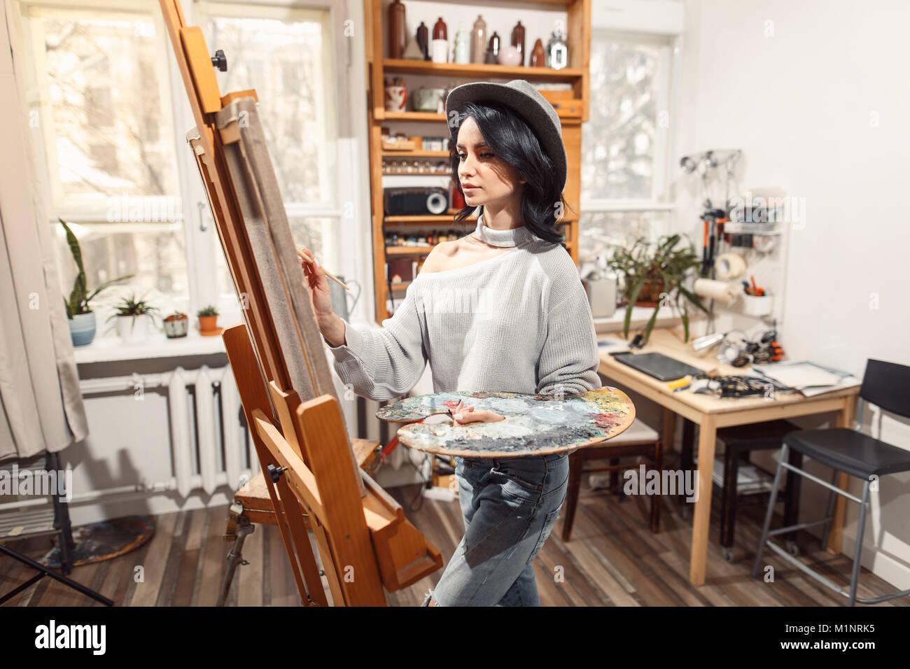 Ragazza sorridente pitture su tela con colori ad olio in laboratorio Foto Stock