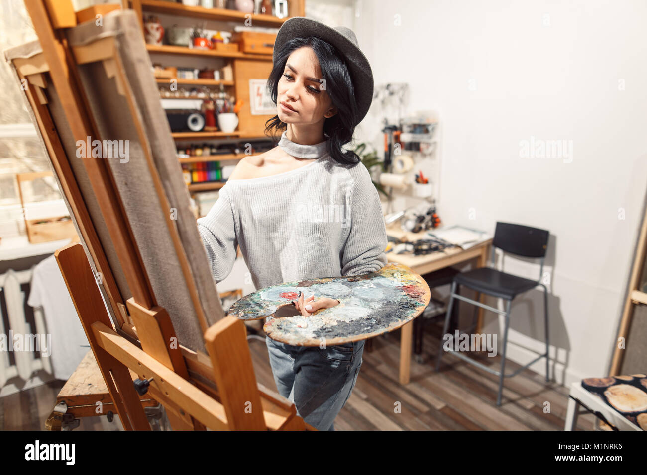 Ragazza sorridente pitture su tela con colori ad olio in laboratorio Foto Stock