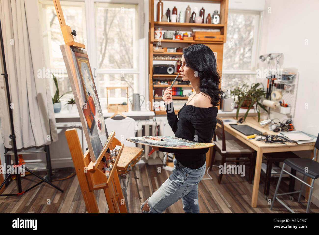 Ragazza sorridente pitture su tela con colori ad olio in laboratorio Foto Stock