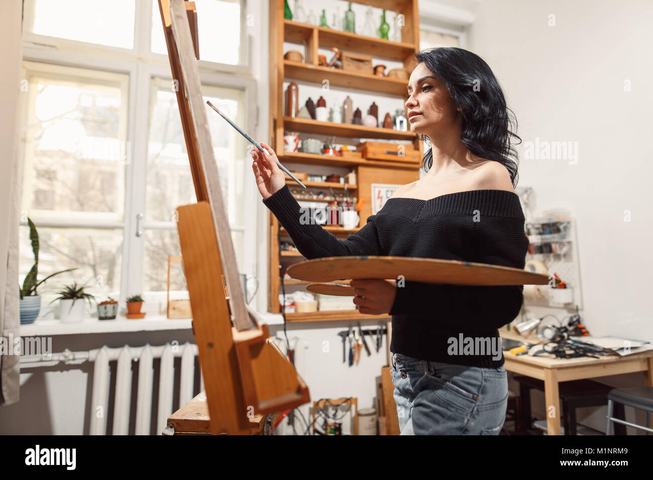 Ragazza sorridente pitture su tela con colori ad olio in laboratorio Foto Stock