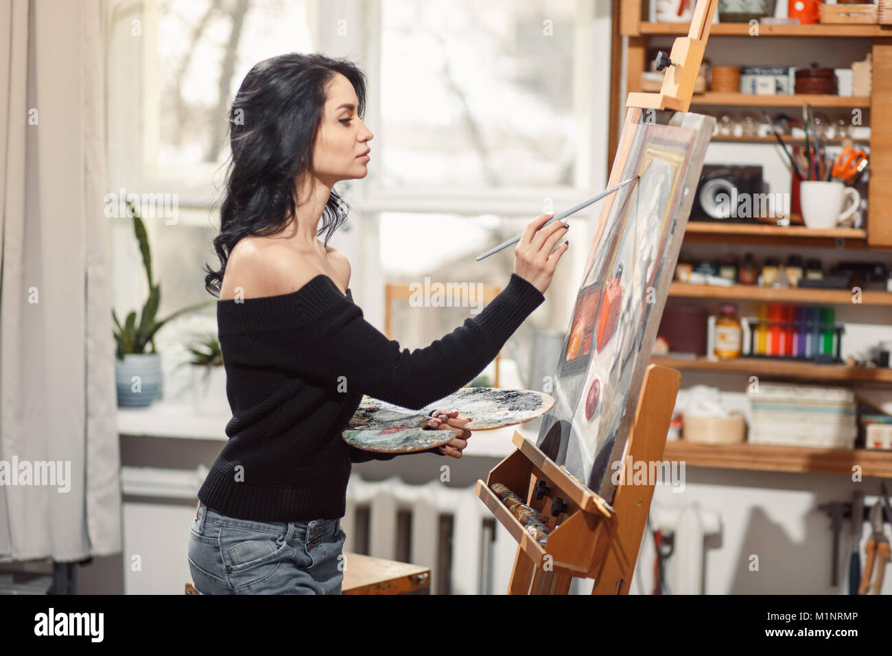 Ragazza sorridente pitture su tela con colori ad olio in laboratorio Foto Stock