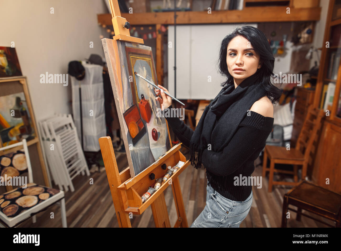 Ragazza sorridente pitture su tela con colori ad olio in laboratorio Foto Stock