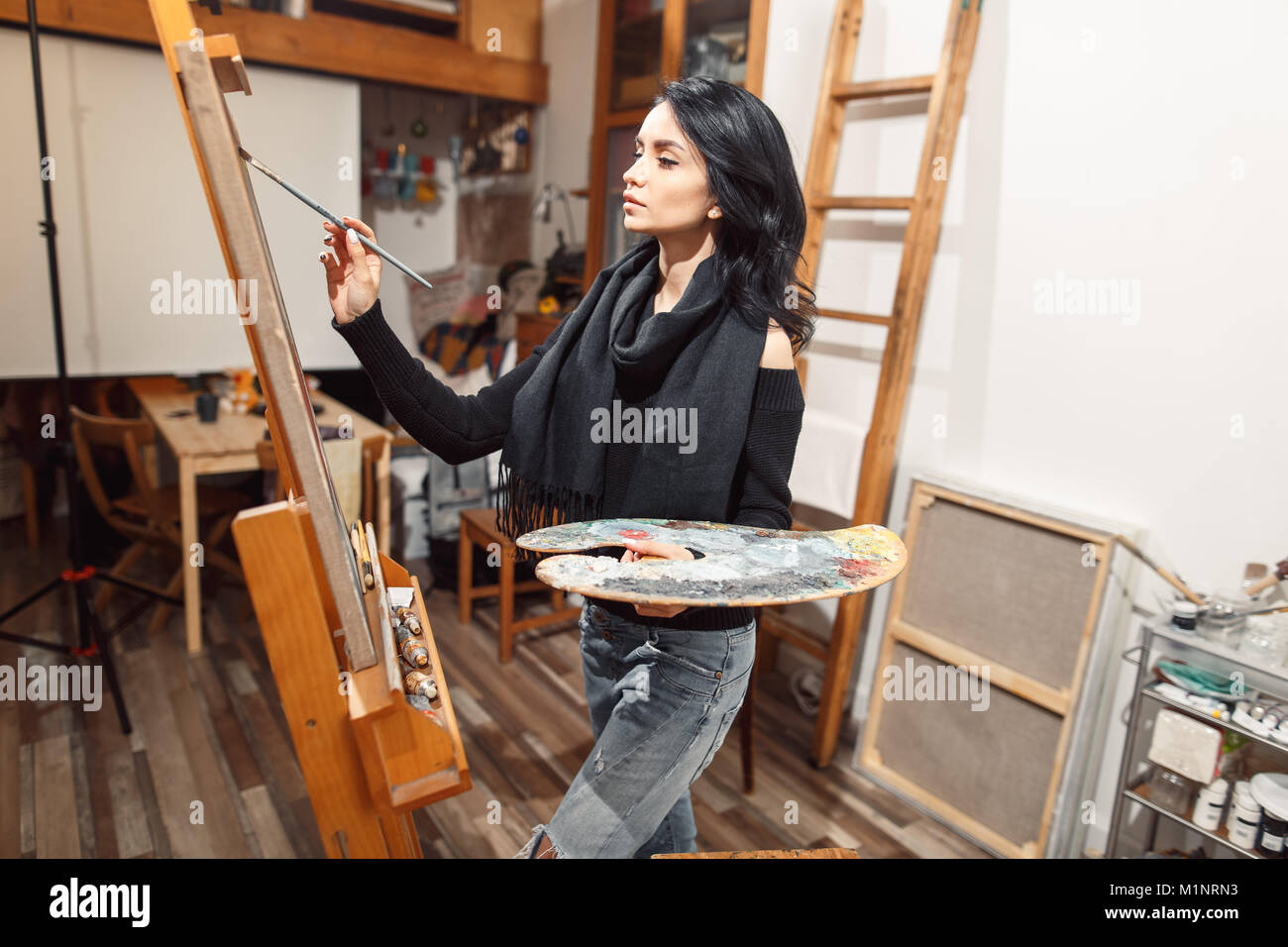 Ragazza sorridente pitture su tela con colori ad olio in laboratorio Foto Stock