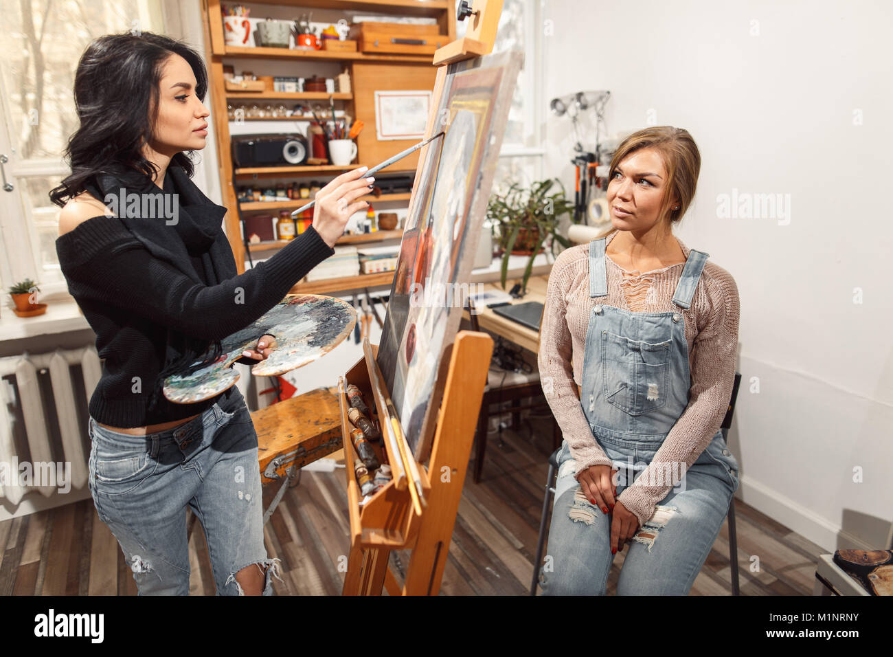 Due ragazze in un artista studio. vernici modello Foto Stock