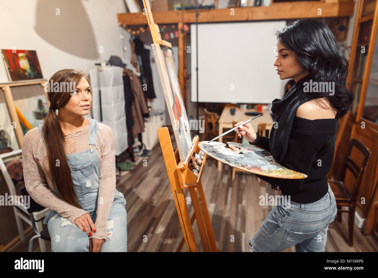 Due ragazze in un artista studio. vernici modello Foto Stock