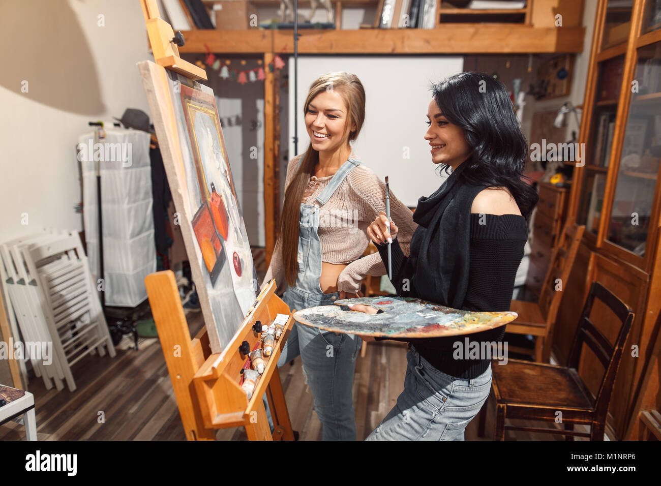 Due ragazze in un artista studio. vernici modello Foto Stock