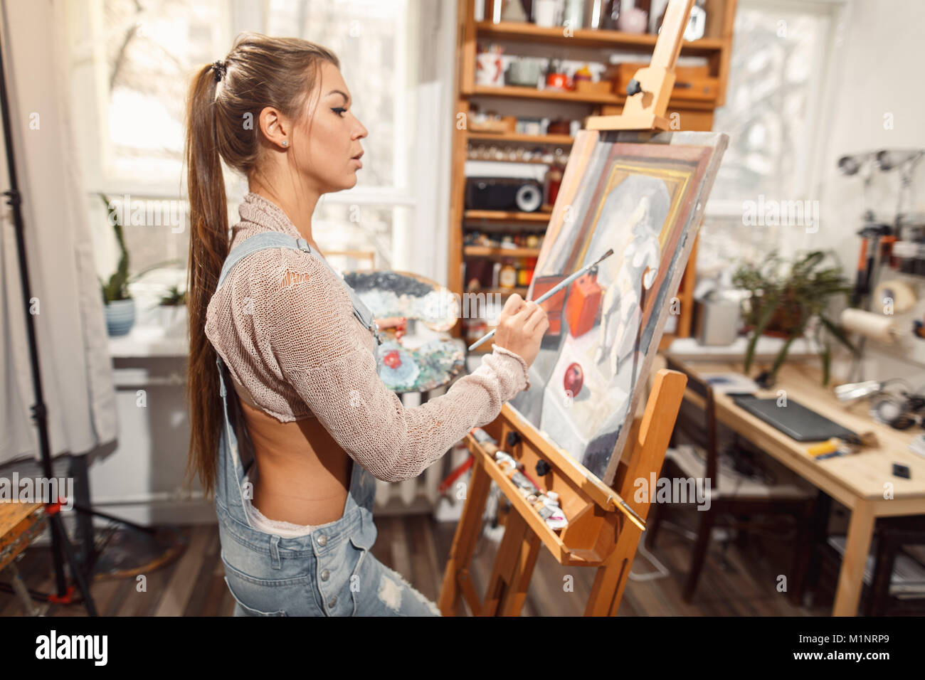 Ragazza sorridente pitture su tela con colori ad olio in laboratorio Foto Stock