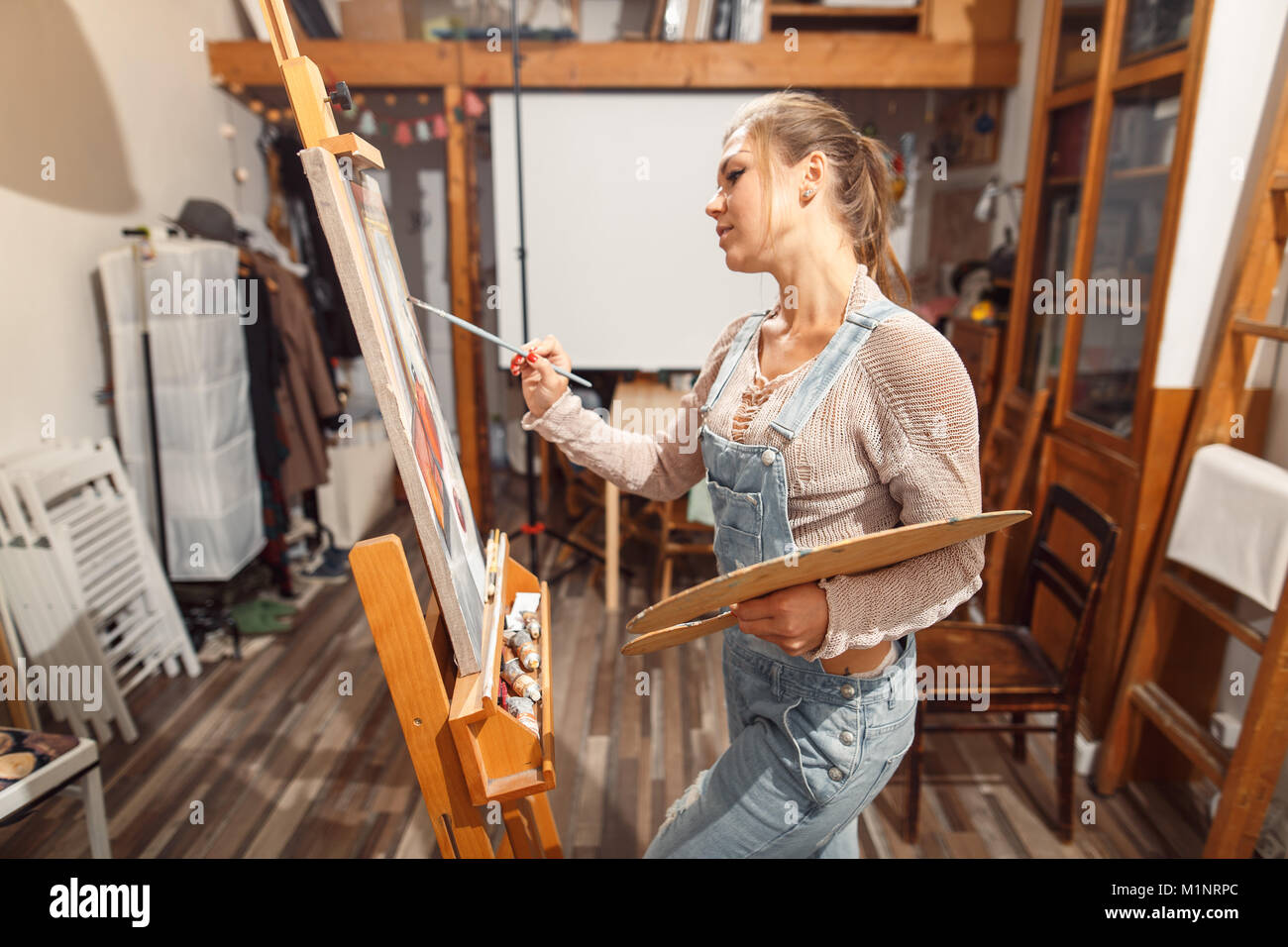 Ragazza sorridente pitture su tela con colori ad olio in laboratorio Foto Stock