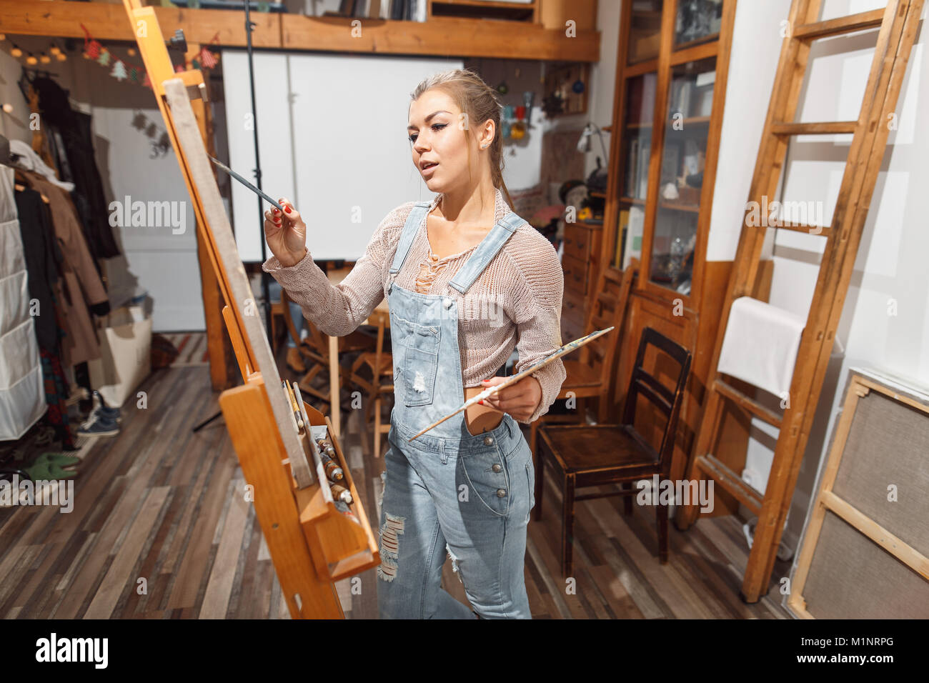 Ragazza sorridente pitture su tela con colori ad olio in laboratorio Foto Stock