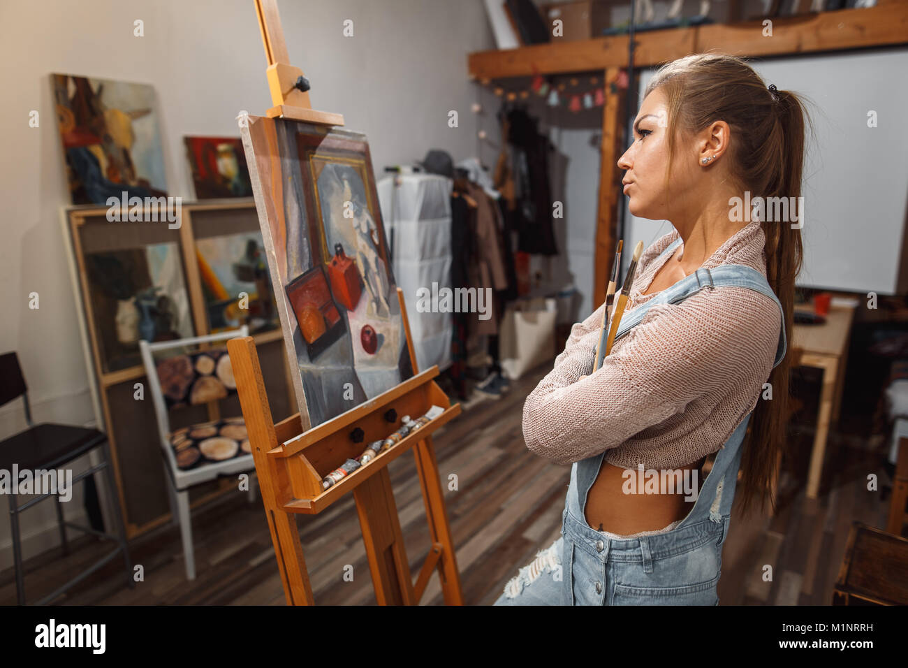 Ragazza sorridente pitture su tela con colori ad olio in laboratorio Foto Stock