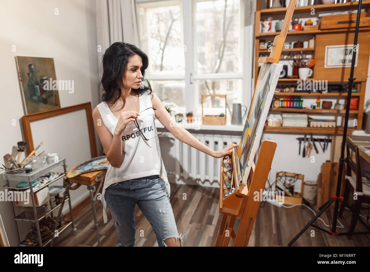 Ragazza sorridente pitture su tela con colori ad olio in laboratorio Foto Stock