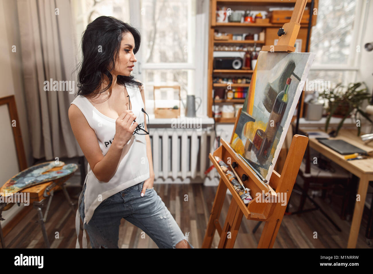 Ragazza sorridente pitture su tela con colori ad olio in laboratorio Foto Stock