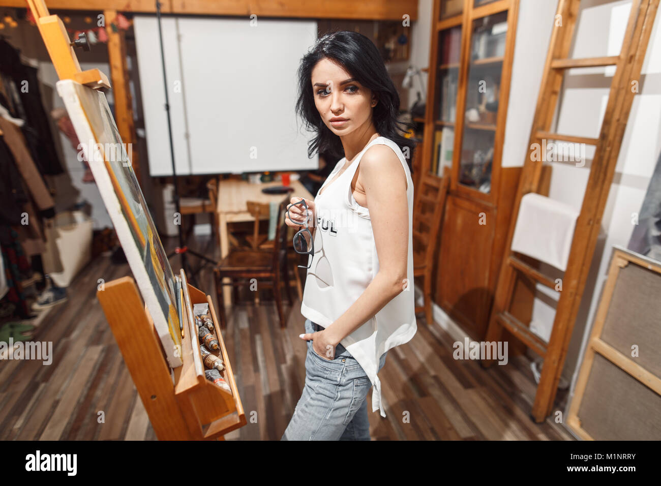 Ragazza sorridente pitture su tela con colori ad olio in laboratorio Foto Stock