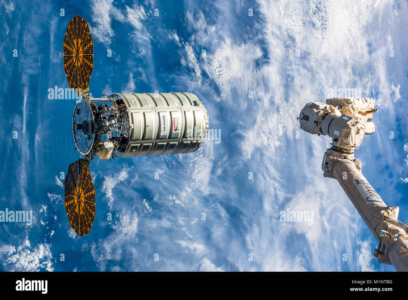 Il Cygnus lander è un americano di carico automatizzati. È stato sviluppato ATK orbitale. Il Canadarm si estende per ottenere un grip della nave. Questa immagine el Foto Stock