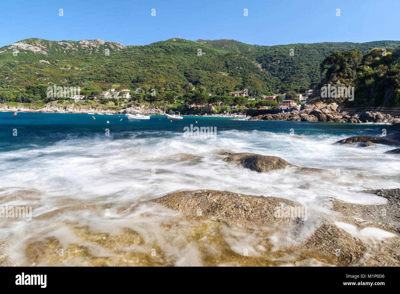 Onde che si infrangono sulle rocce e spiaggia di Pomonte, Marciana, Isola d'Elba, Provincia di Livorno, Toscana, Italia, Europa Foto Stock