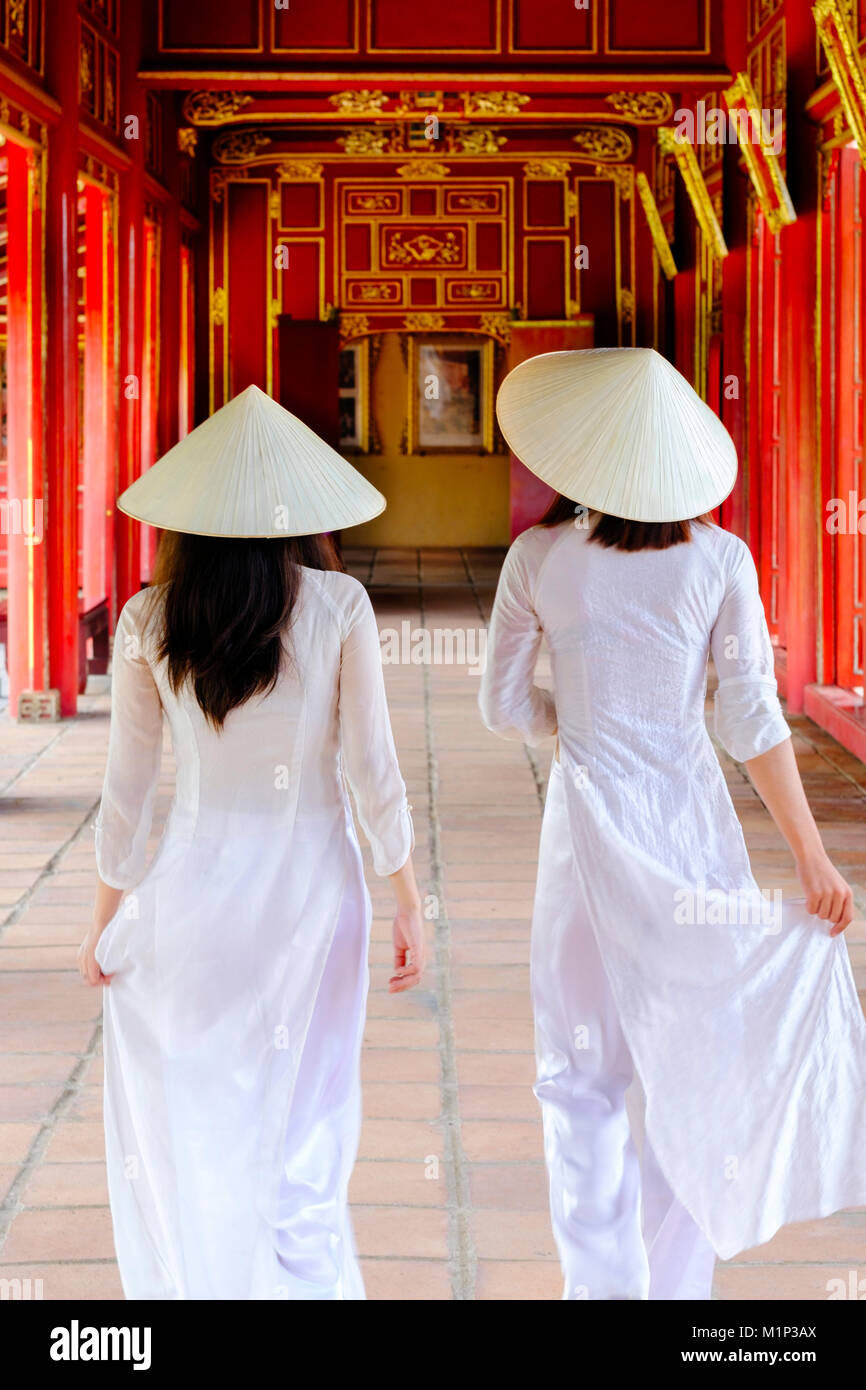 Due donne vietnamita in tradizionale Ao dai vestiti e non la cappelli nella Città Purpurea Proibita di tonalità, Thua Thien Huê, Vietnam, Indocina, Asia Foto Stock