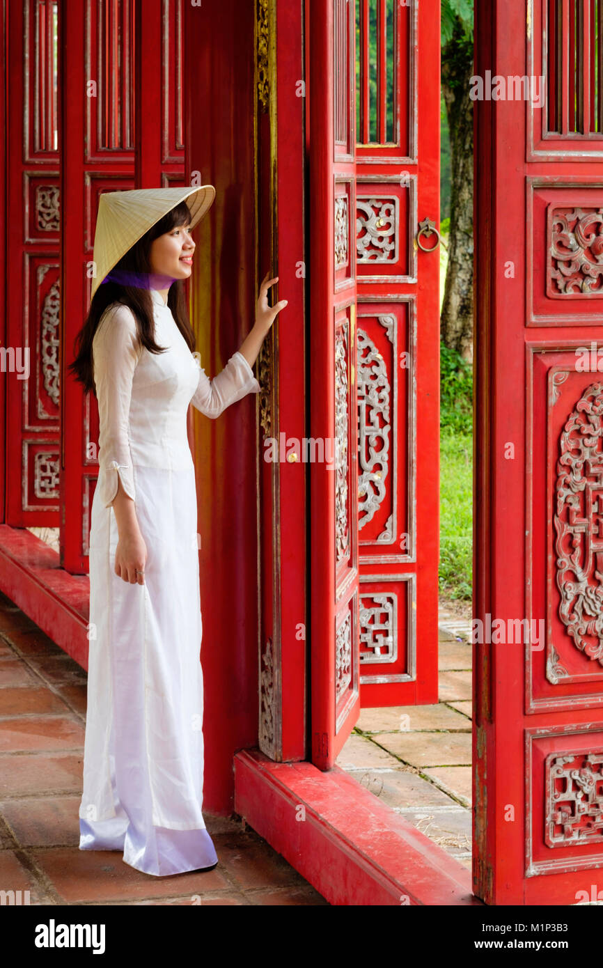 Una donna in un tradizionale Ao Dai vestire e non la cappello conico nella Città Purpurea Proibita di tonalità, UNESCO, Thua Thien Huê, Vietnam, Indocina, Asia Foto Stock