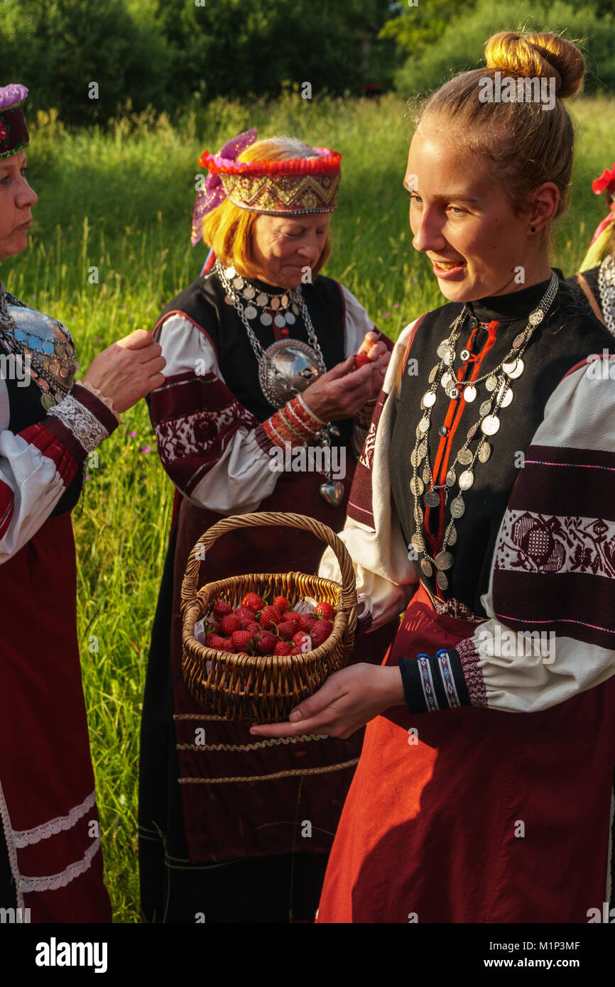 Seto ragazza offre fragole selvatiche ad amici, giorno di festa, Uusvada, Setomaa, se l'Estonia, Europa Foto Stock