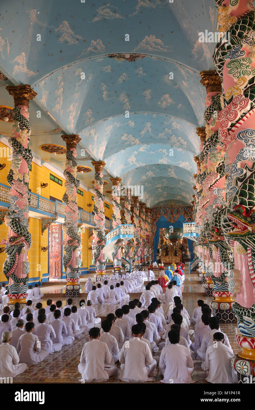 Pregando pii uomini e donne, cerimoniale di preghiera di mezzogiorno, Cao Dai Santa Sede Tempio Tay Ninh, Vietnam, Indocina, Asia sud-orientale, Asia Foto Stock