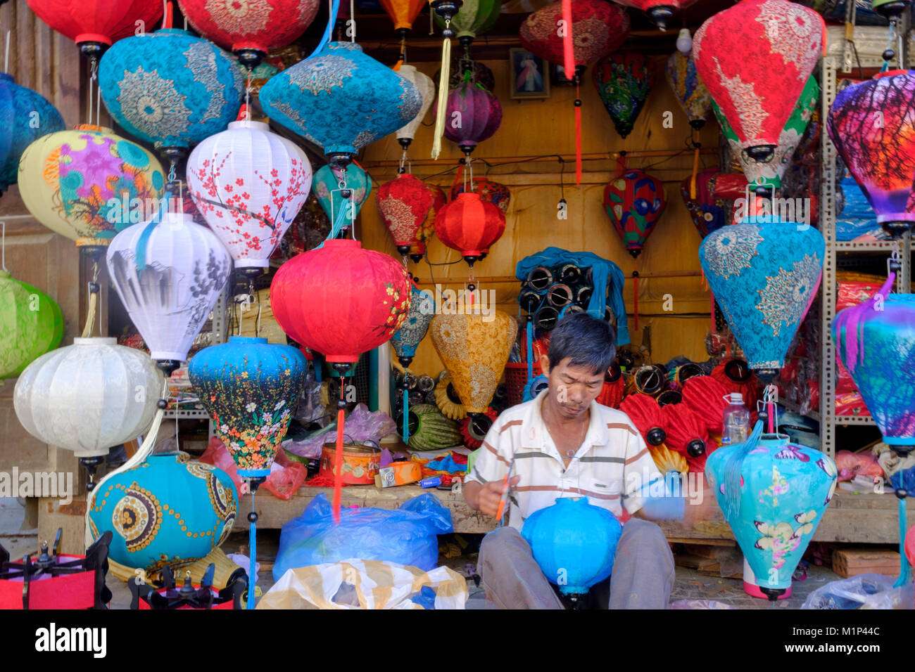 Un uomo che fa le lanterne di carta in un negozio di Hoi An, Vietnam, Indocina, Asia sud-orientale, Asia Foto Stock