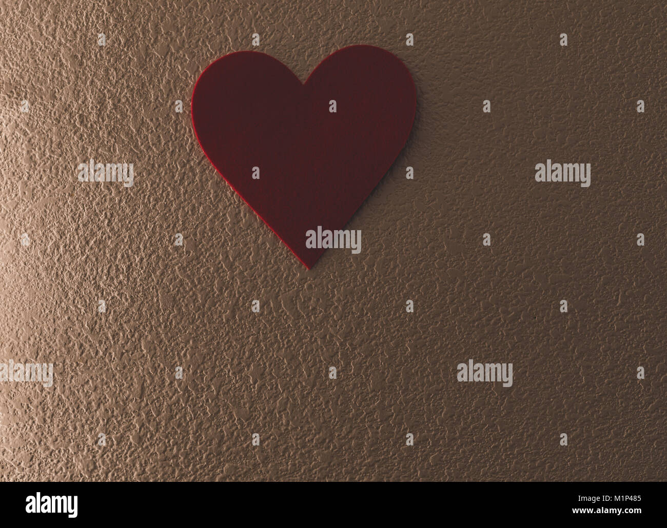 Unico cuore rosso appeso alla parete lasciando spazio sulla parte inferiore del telaio per il testo e per i messaggi. Foto Stock