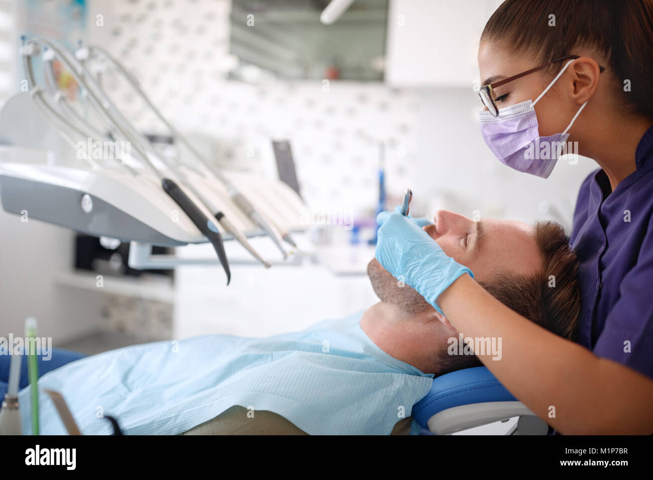 Dentista femmina lavora con i pazienti di sesso maschile Foto Stock