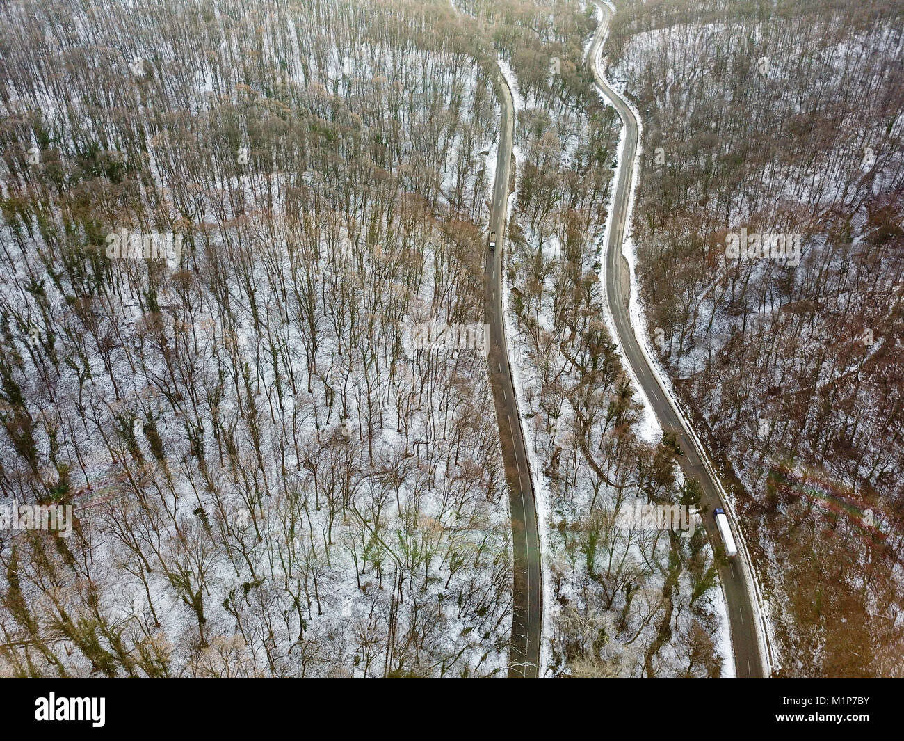 Vista dall'altezza sul car guida attraverso l'inverno strada forestale. Scenic paesaggio invernale Foto Stock
