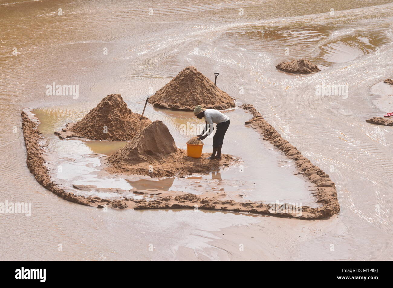 Gethering, vincente, raccolta di sabbia in un fiume. È una foto in Malavi Foto Stock