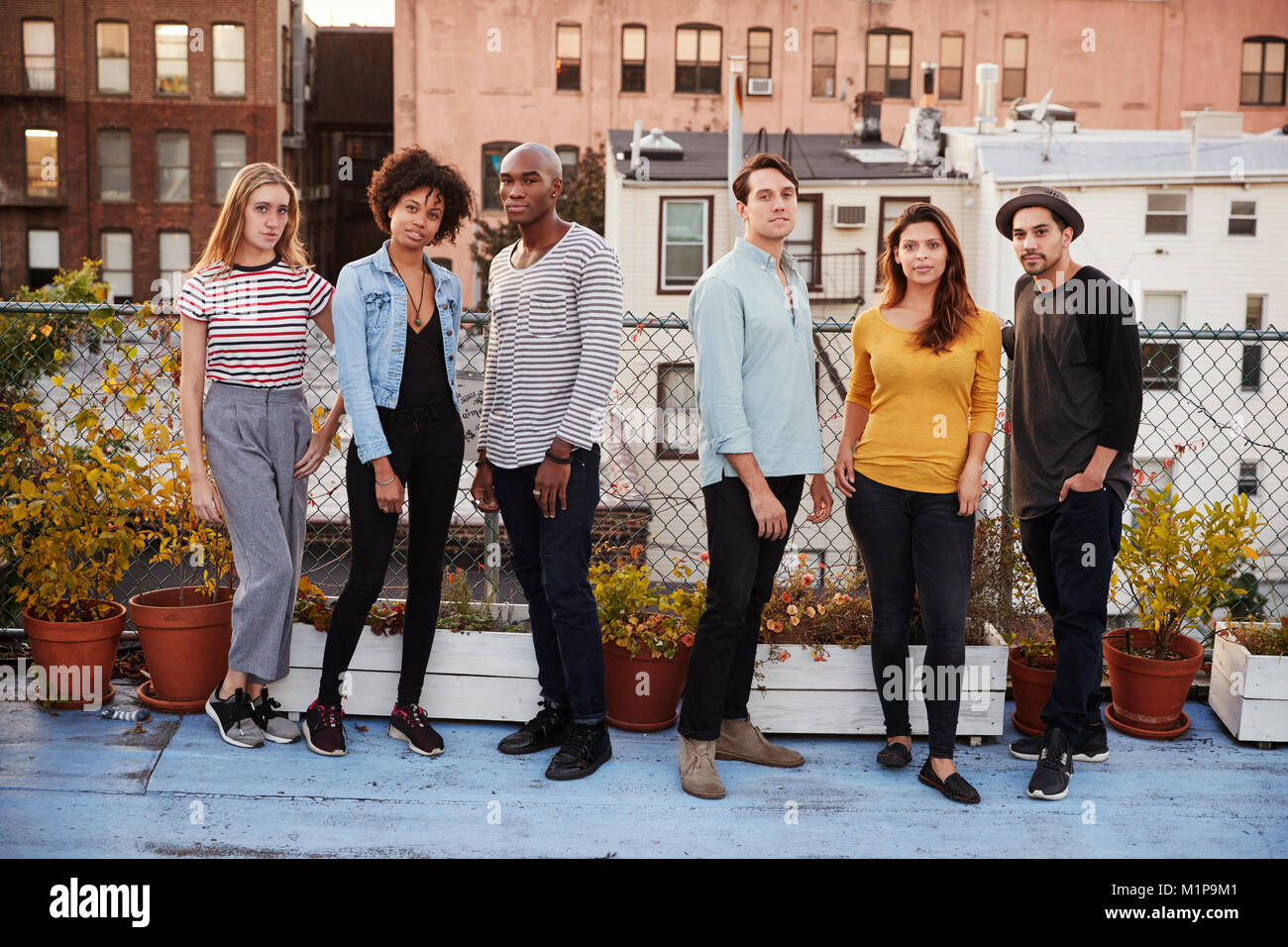 Sei amici adulti insieme permanente sul tetto a piena lunghezza Foto Stock