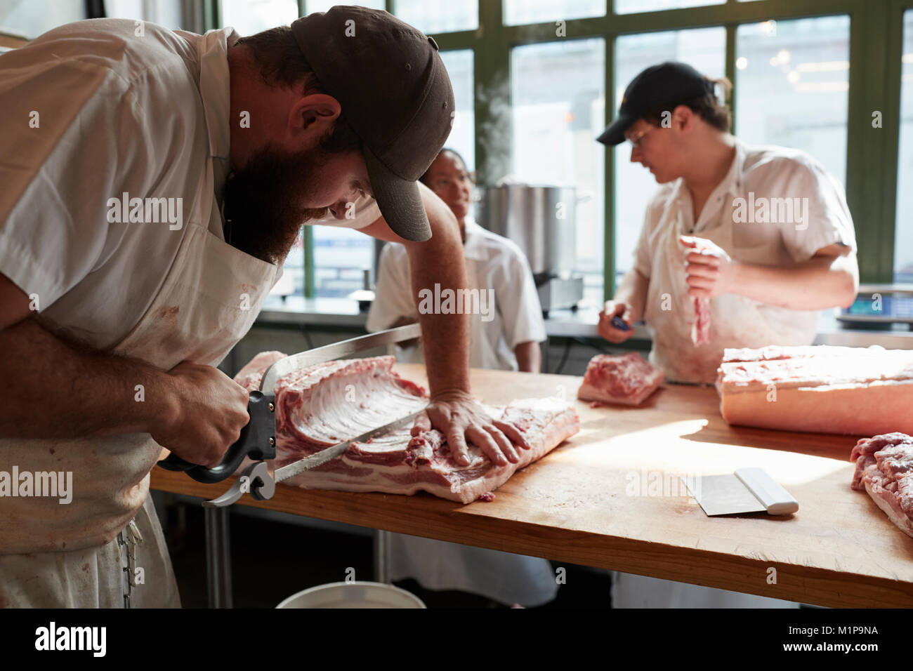 Tre macellerie preparare carne,di tagli di carne in macelleria, close up Foto Stock