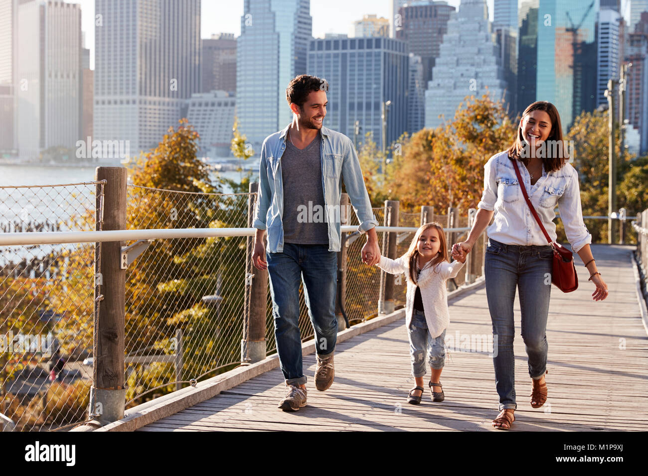 Famiglia giovane con la figlia facendo una passeggiata sulla passerella Foto Stock