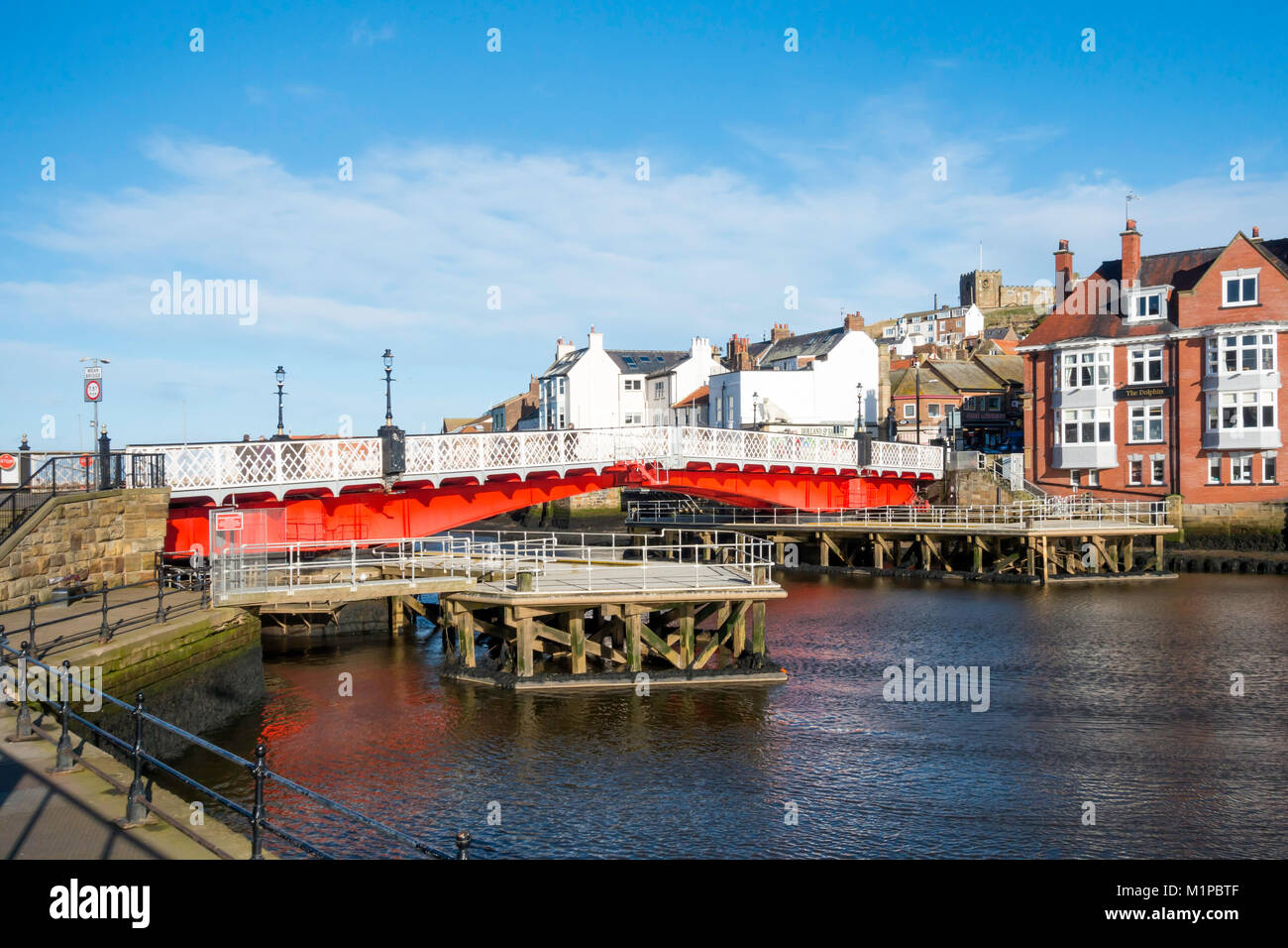 Whitby ponte girevole vivacemente dipinte di rosso visto dal lato ovest del fiume Esk con strutture di guida per evitare danni dal passaggio di barche Foto Stock