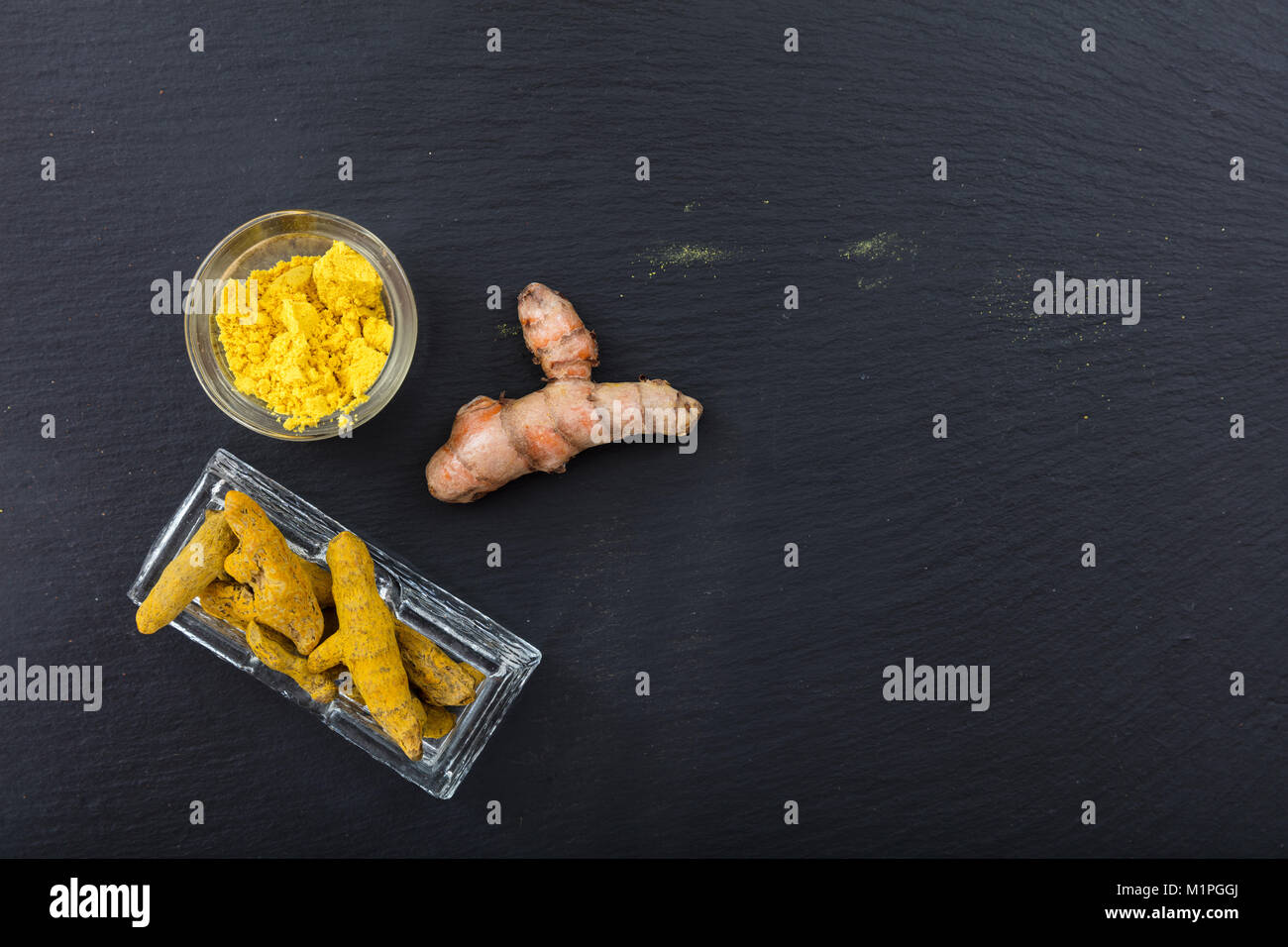 Freschi e Secchi o di curcuma curcumina radici e polvere su sfondo nero. Vista superiore, spazio di copia Foto Stock
