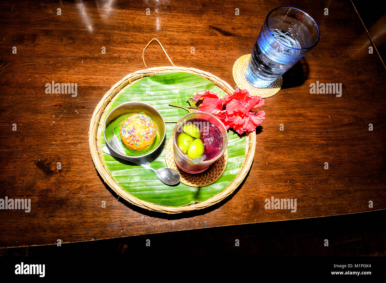 Vassoio con una torta e una farfalla Blu fiore di pisello bere, decorato con fiori di ibisco, Sabah Borneo, Malaysia Foto Stock